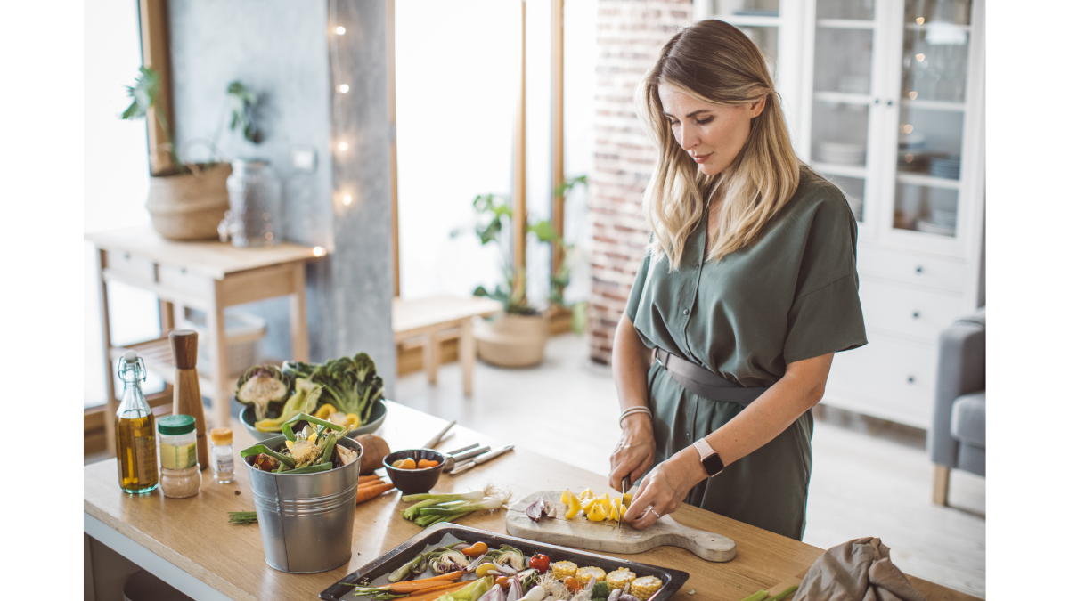 Mulher na cozinha preparando comida saudável em casa. (Imagem: Canva).