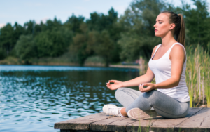 Mulher praticando o autocuidado por meio da meditação.