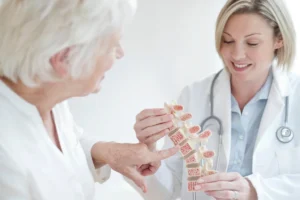 Médica explicando para idosa sobre a osteoporose é um dos sinais de fratura óssea.