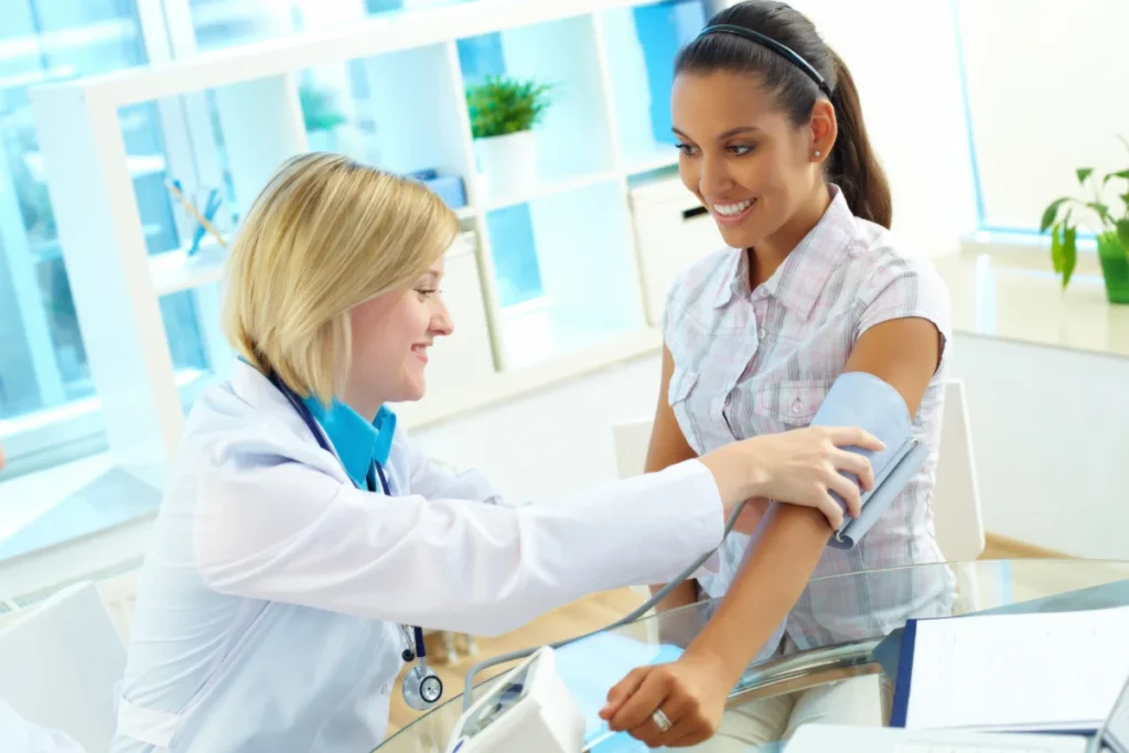 Médica monitorando a pressão arterial da mulher.