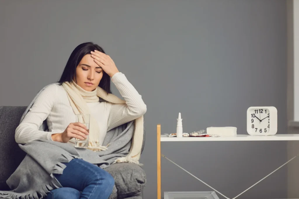 Mulher tomando remédios para controlar a febre emocional.