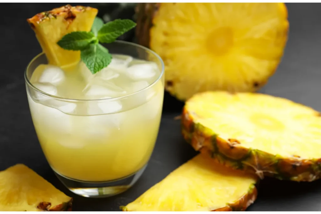 Suco detox de abacaxi com cubos de gelo e hortelã.