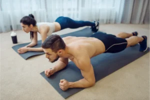 Casal realizando treino em casa para tonificar o corpo.
