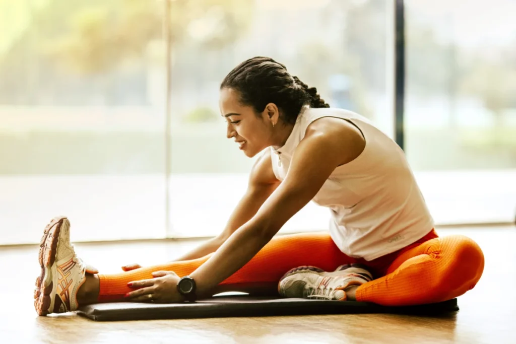 Jovem realizando alongamento pós-treino de cardio.