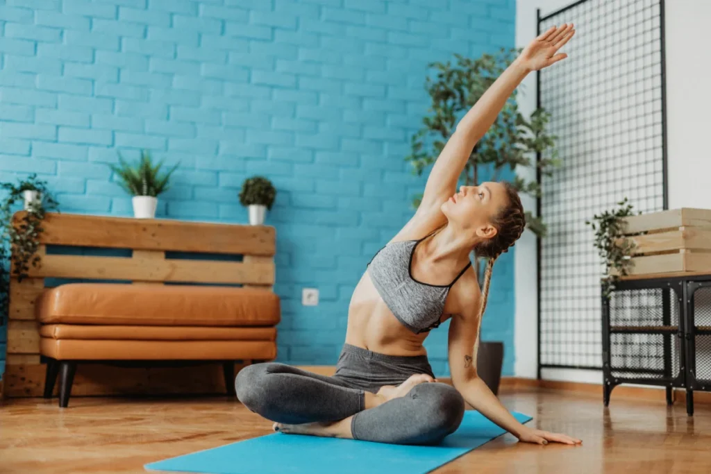 Mulher praticando yoga em casa.