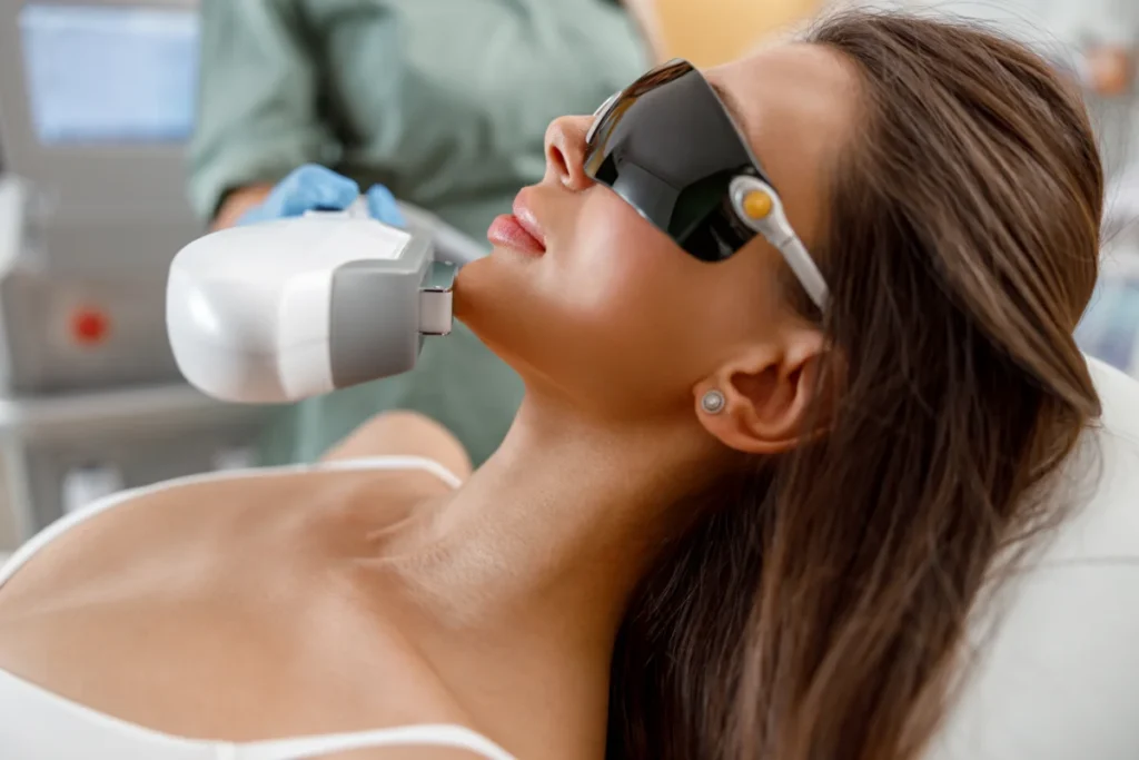 Mulher realizando tratamento facial com luz pulsada.