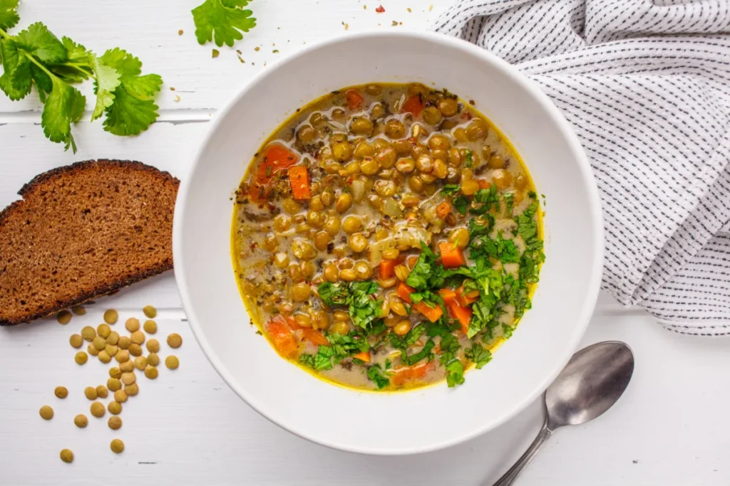 Sopa caseira de lentilha vegana com legumes e coentro.