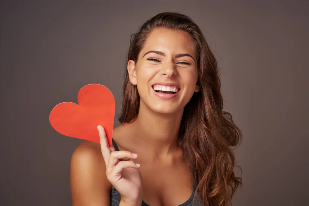 Mulher jovem sorrindo, refletindo seu humor equilibrado.