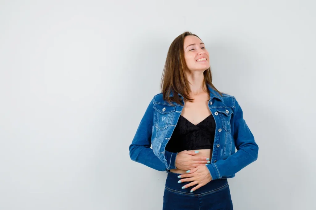 Mulher jovem sentindo alívio intestinal e sorrindo. (