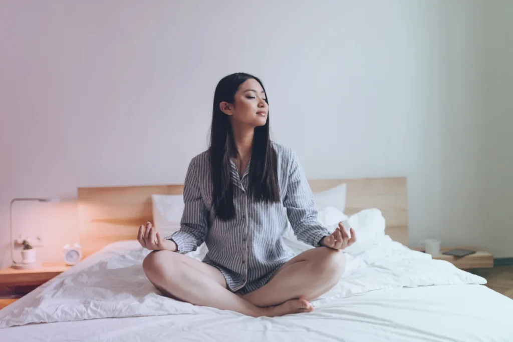 Mulher jovem meditando antes de dormir.